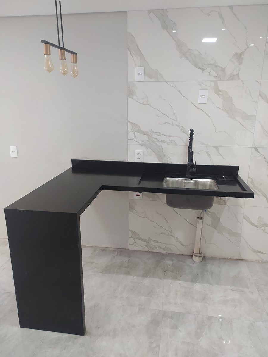 Bancada de cozinha em granito preto com cuba e pendentes sobre a bancada