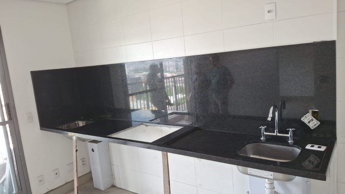 Bancada em granito preto com cuba de inox e torneira instalada