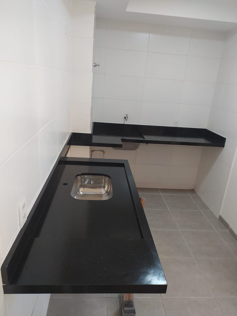 Bancada em granito preto em formato de L com cuba de inox